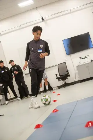 Soccer player in lab kicking ball.
