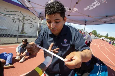 SMU student taping wrist
