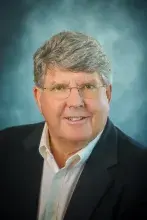 Headshot of man in dark suit