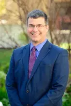 Provost Brian Clocksin standing outside wearing blue suit