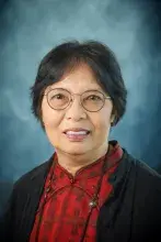 Headshot of woman with brown hair, glasses, and red shirt.