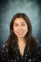Woman with dark hair in floral print shirt