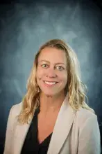 Woman with blond hair and cream colored suit