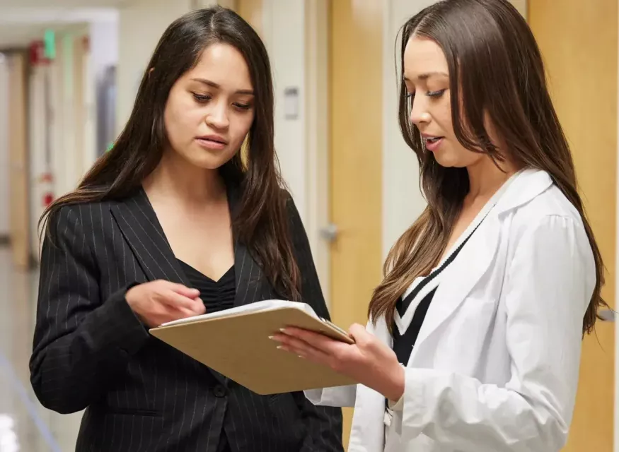 Two mental health nurse clinicians consulting in hallway