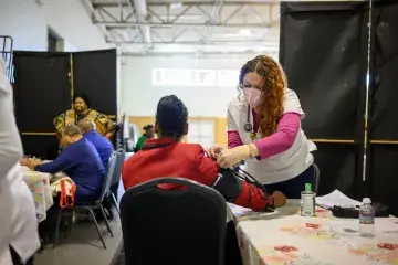 SMU student nurse takes blood pressure of participant at health fair