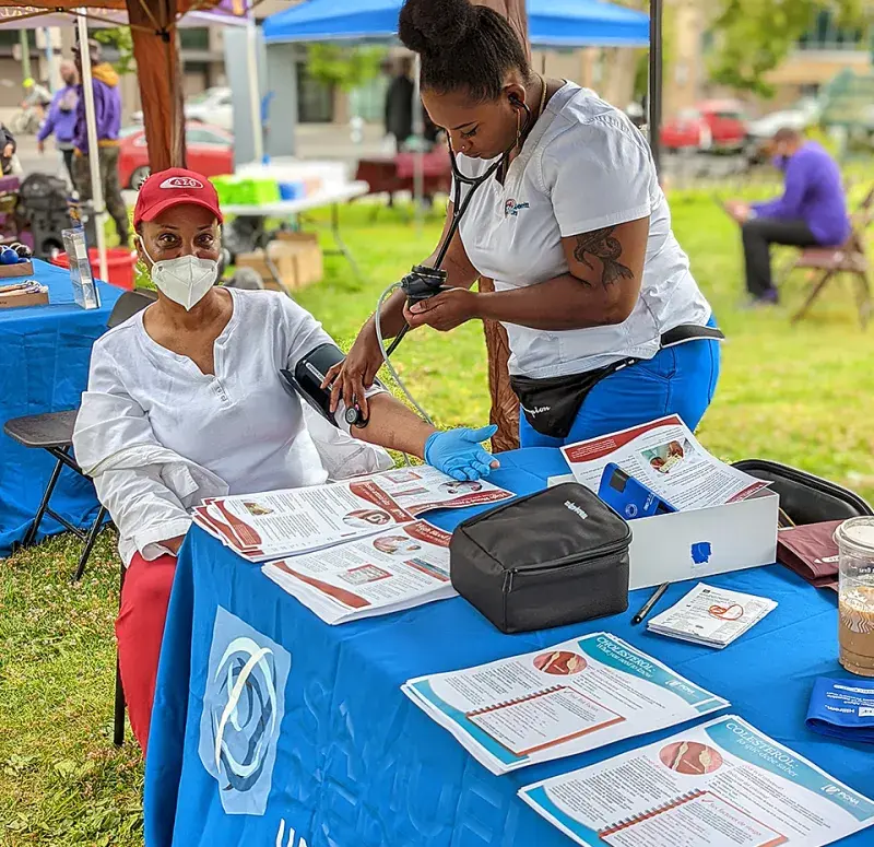 Nursing student does blood pressure check at Lake Merritt health fair.