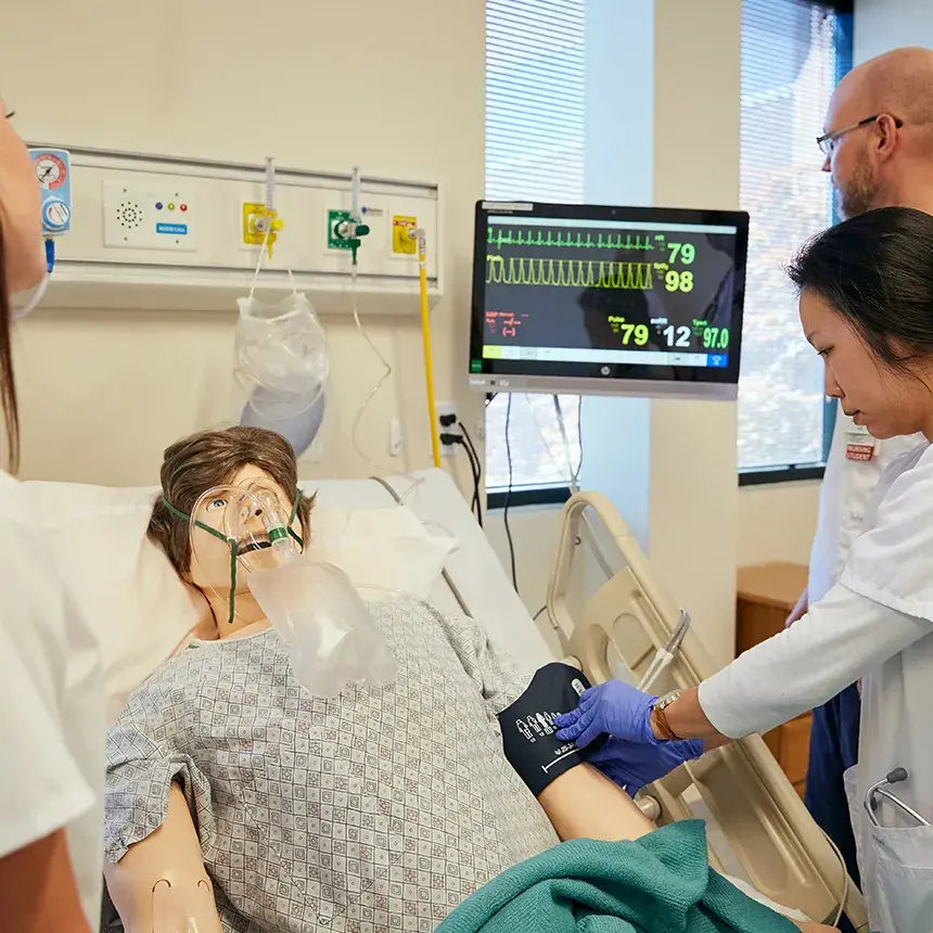 Nurse testing doll's blood pressure