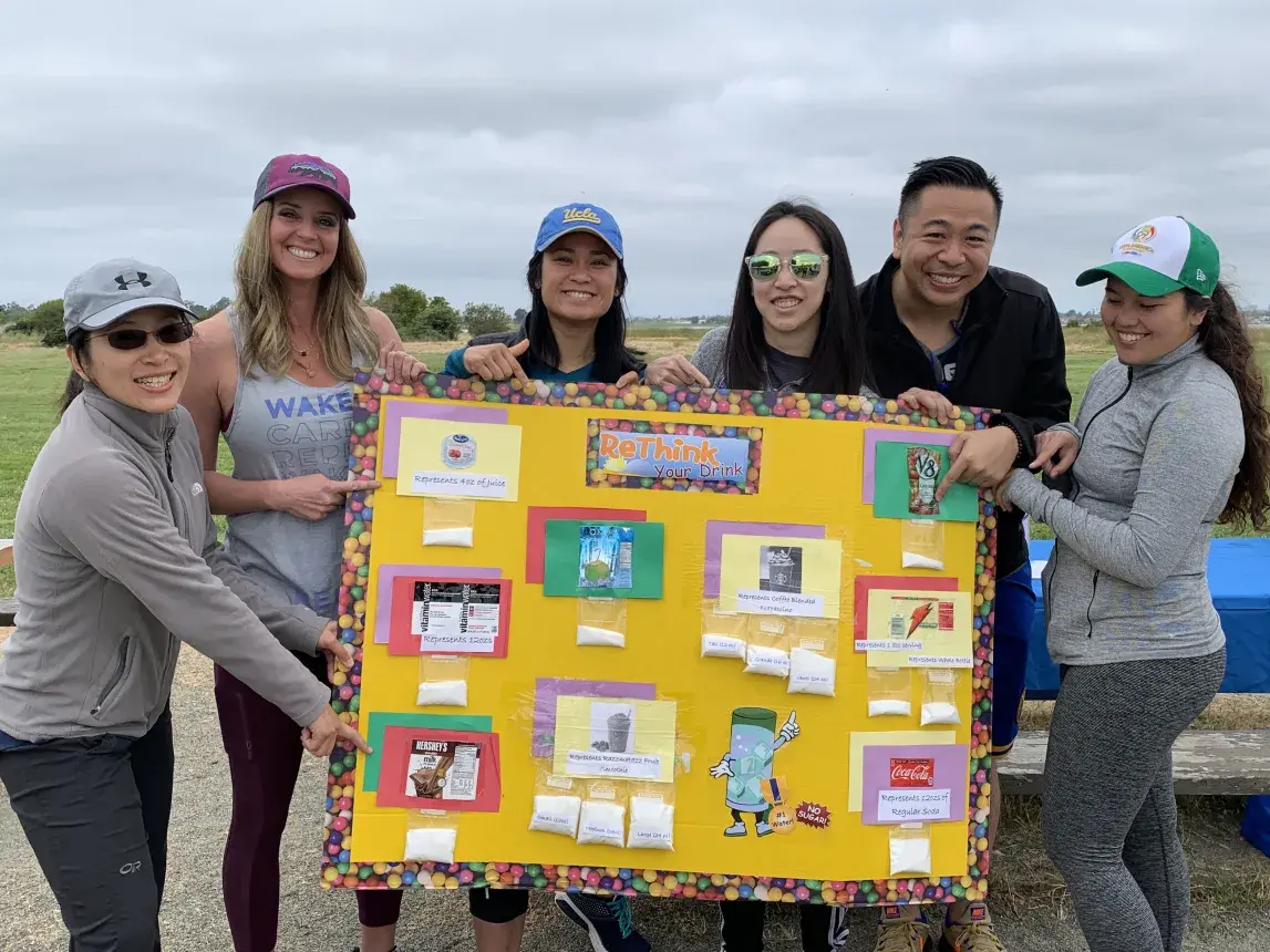 Students holding up healty drink alternative poster