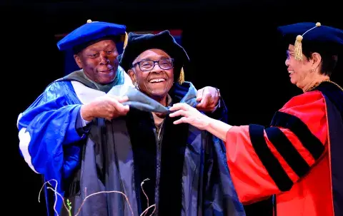 Jovine F. Hankins being hooded by SMU leadership.