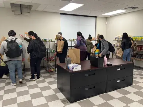 Students gather in the pantry to select items from the shelves.