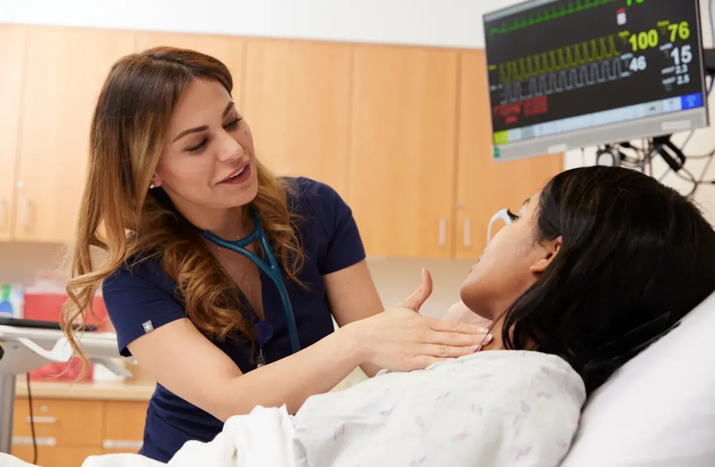 Nurse checking pulse of patient who is lying in bed