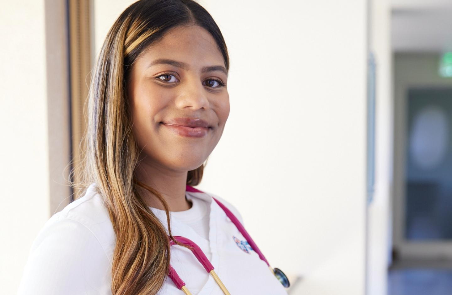 Nurse with stethoscope smiling and looking at camera