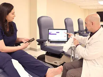 Podiatry Professor Dr. Alexander Reyzelman demonstrates smart socks and associated website and mobile app