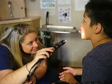 Rebecca Owens exams a student in Elica Health Center's mobile clinic