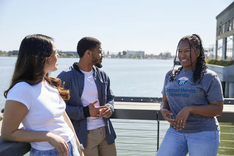 Students talking and standing near Oakland estuary