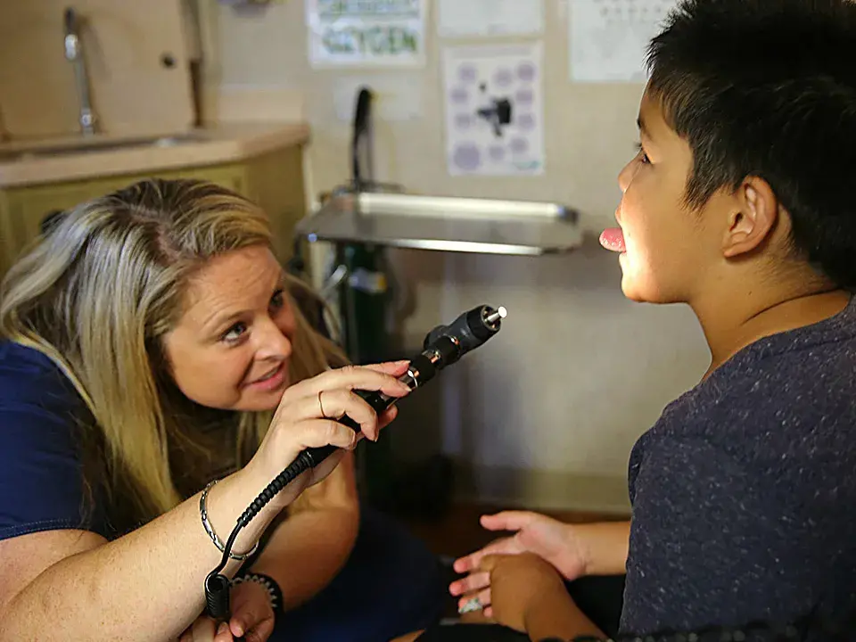 Rebecca Owens exams a student in Elica Health Center's mobile clinic