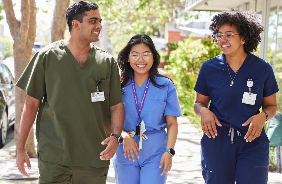 Three students in scrubs walking down the street