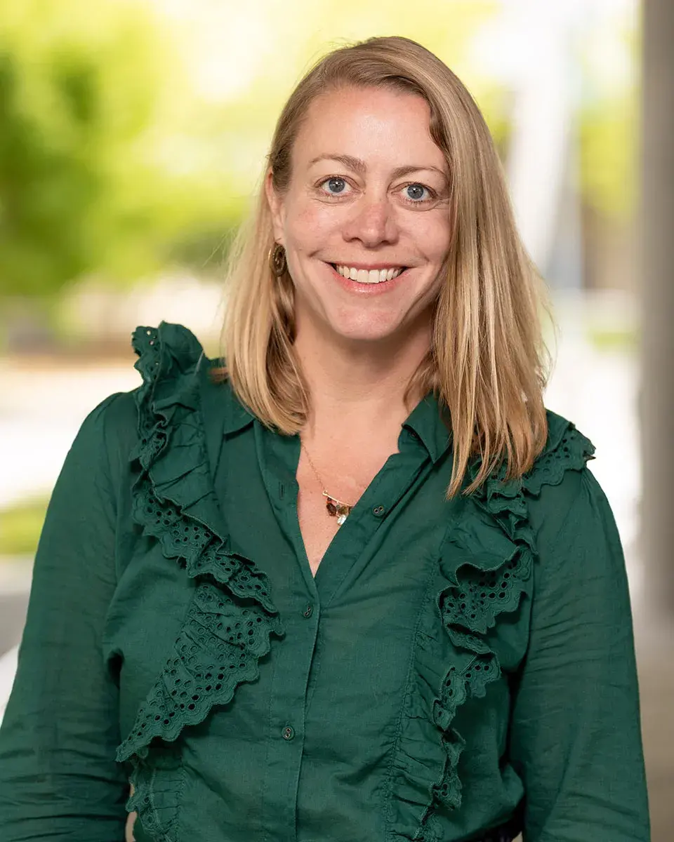 Lindsey McClenahan wearing green ruffled top.